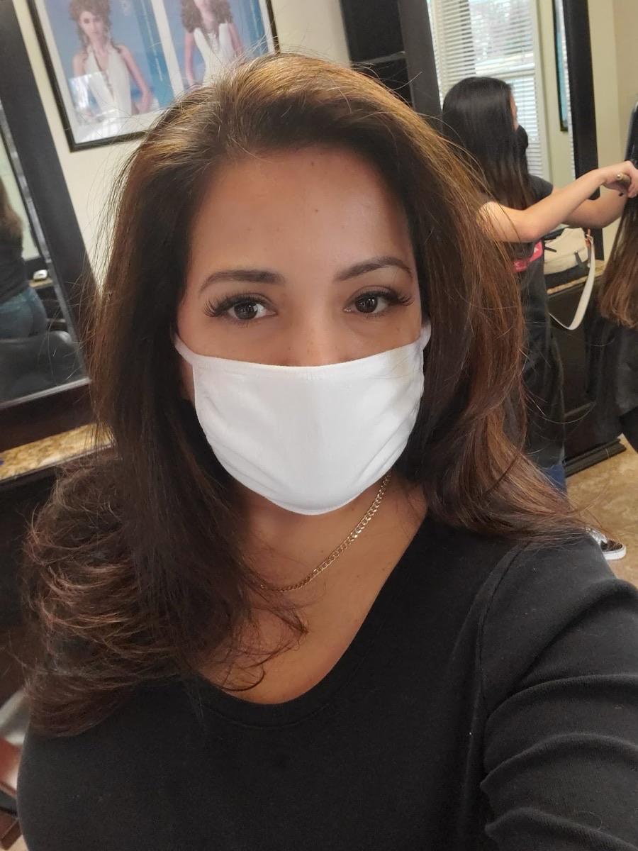 Happy client with a fresh brunette blowout and soft waves