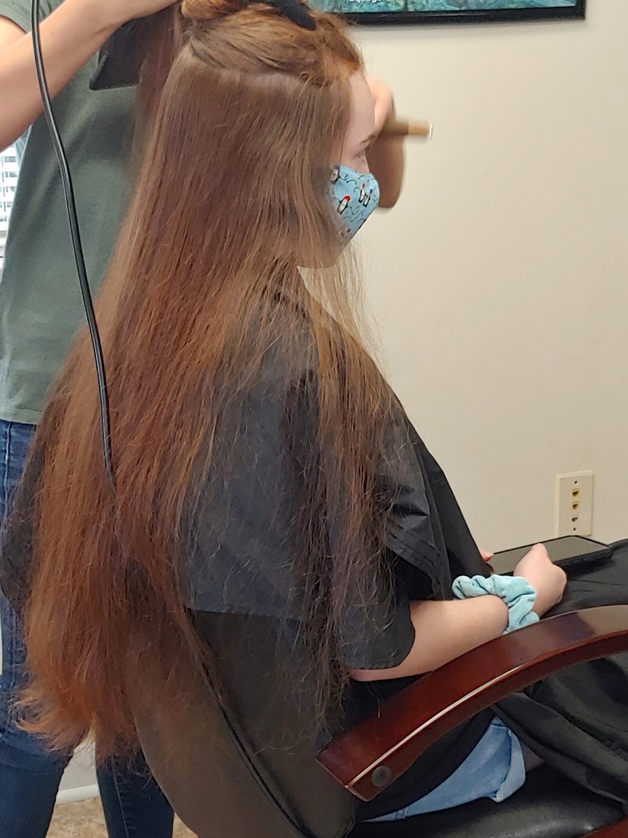 Healthy, very long auburn hair being styled at Holly Salon
